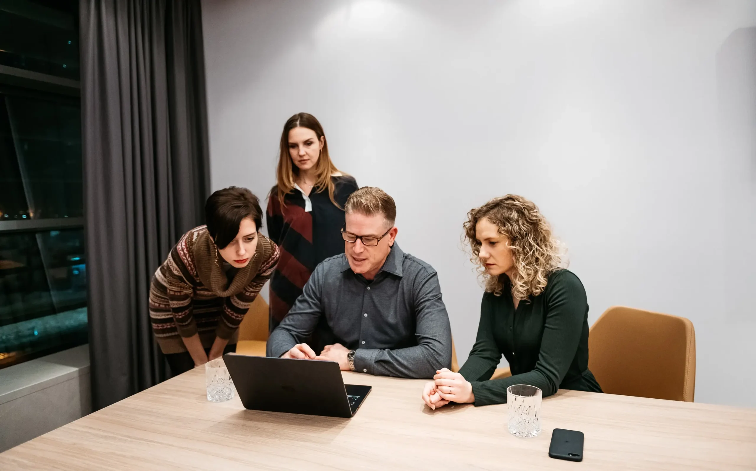 Payfors team gathered around a table in front of a notebook discussing business debt collection strategies